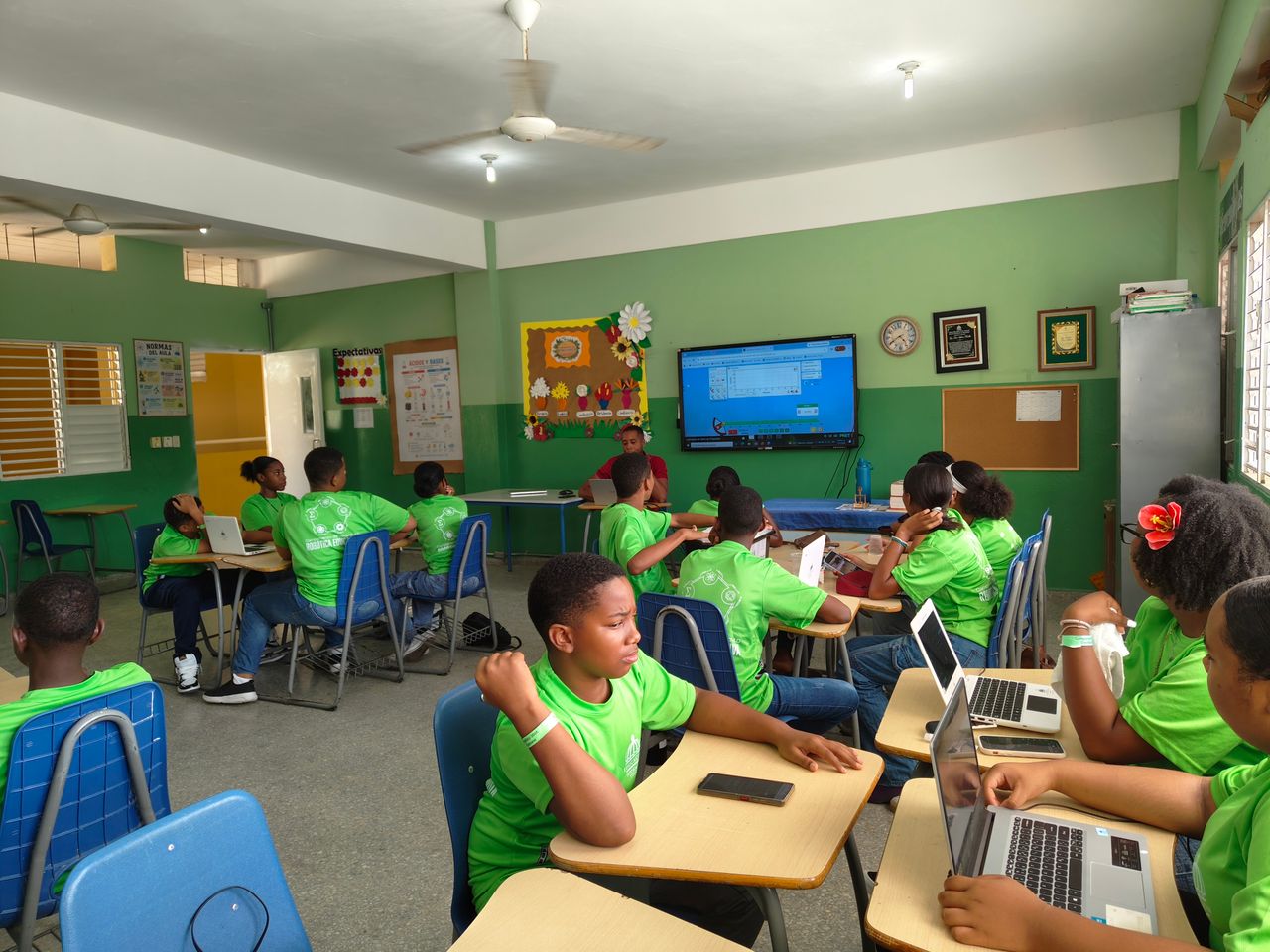 Services Group of students in a classroom using laptops and participating in a lesson.