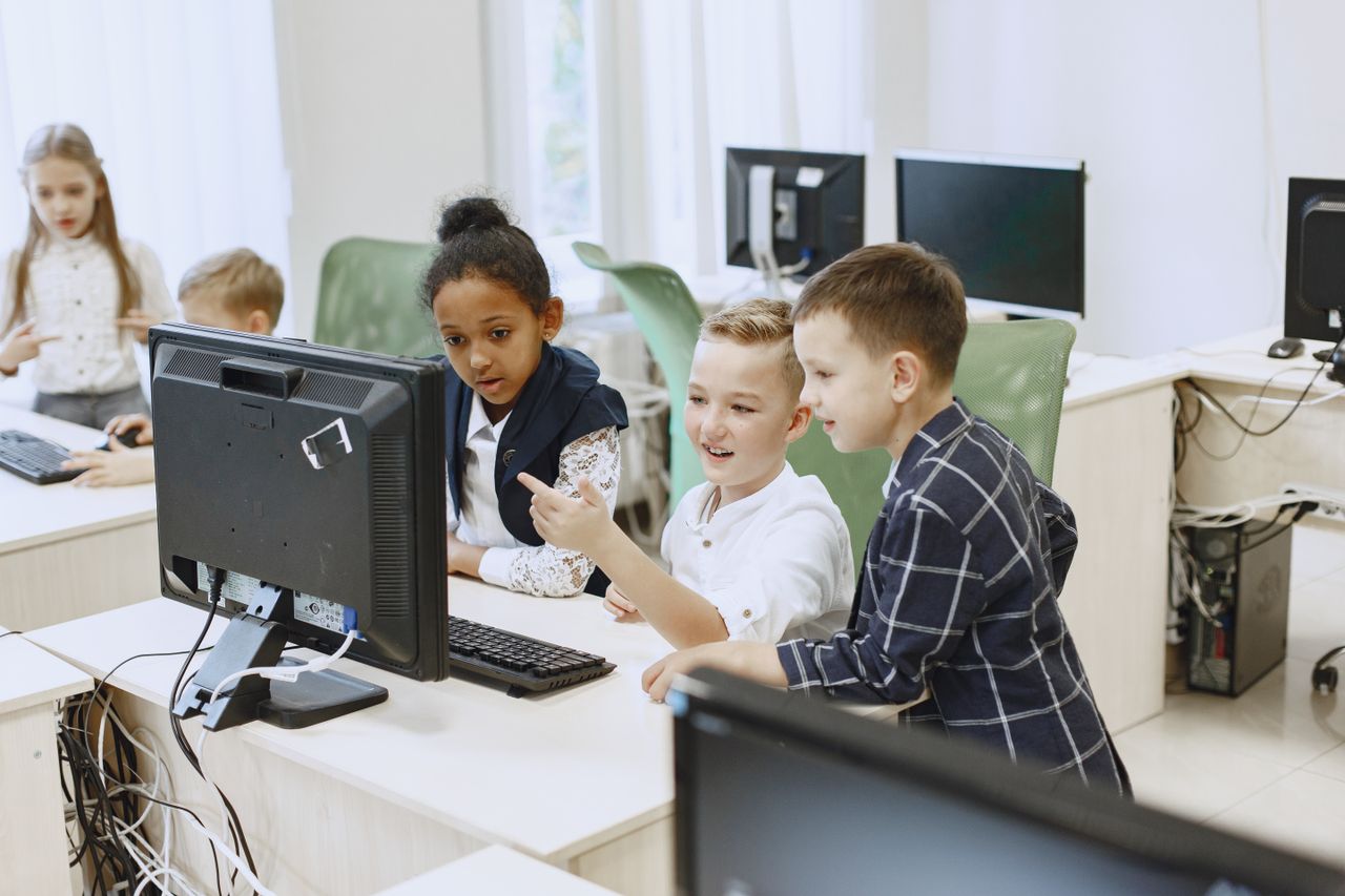 Home Young students engaging with computers in a modern classroom setting.